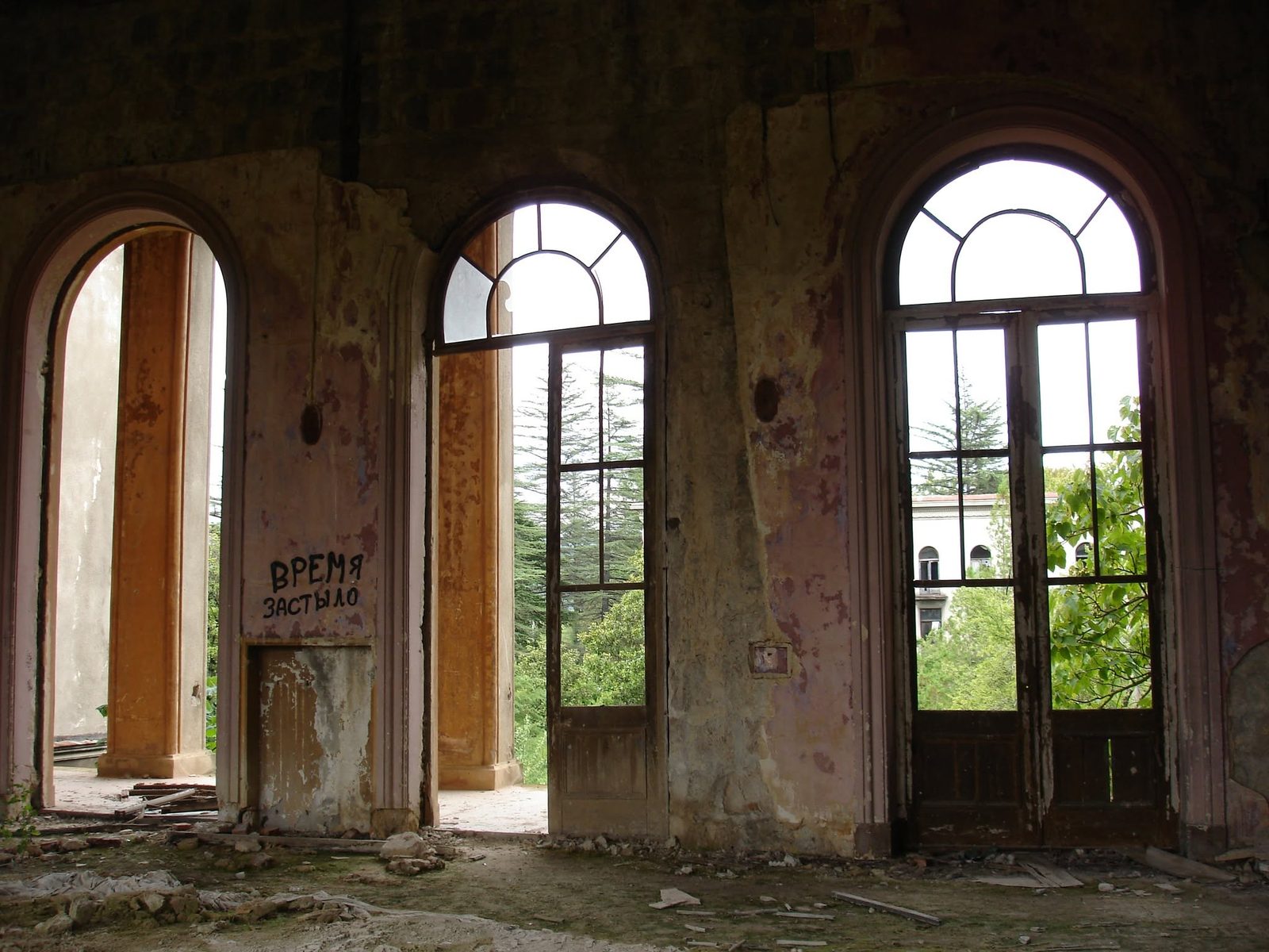 A hall with arched windows. Someone has written “Time stood still” on the wall.
