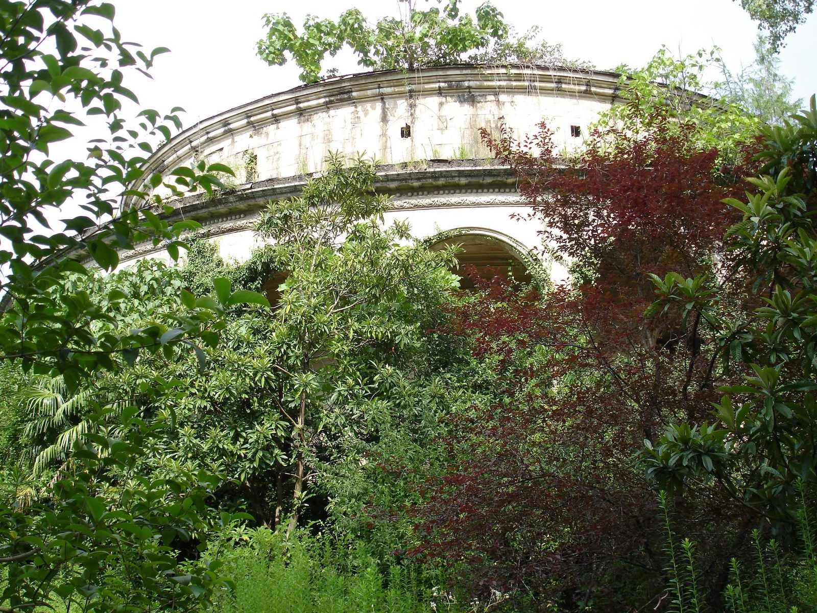 A rotunda almost hidden by vegetation.