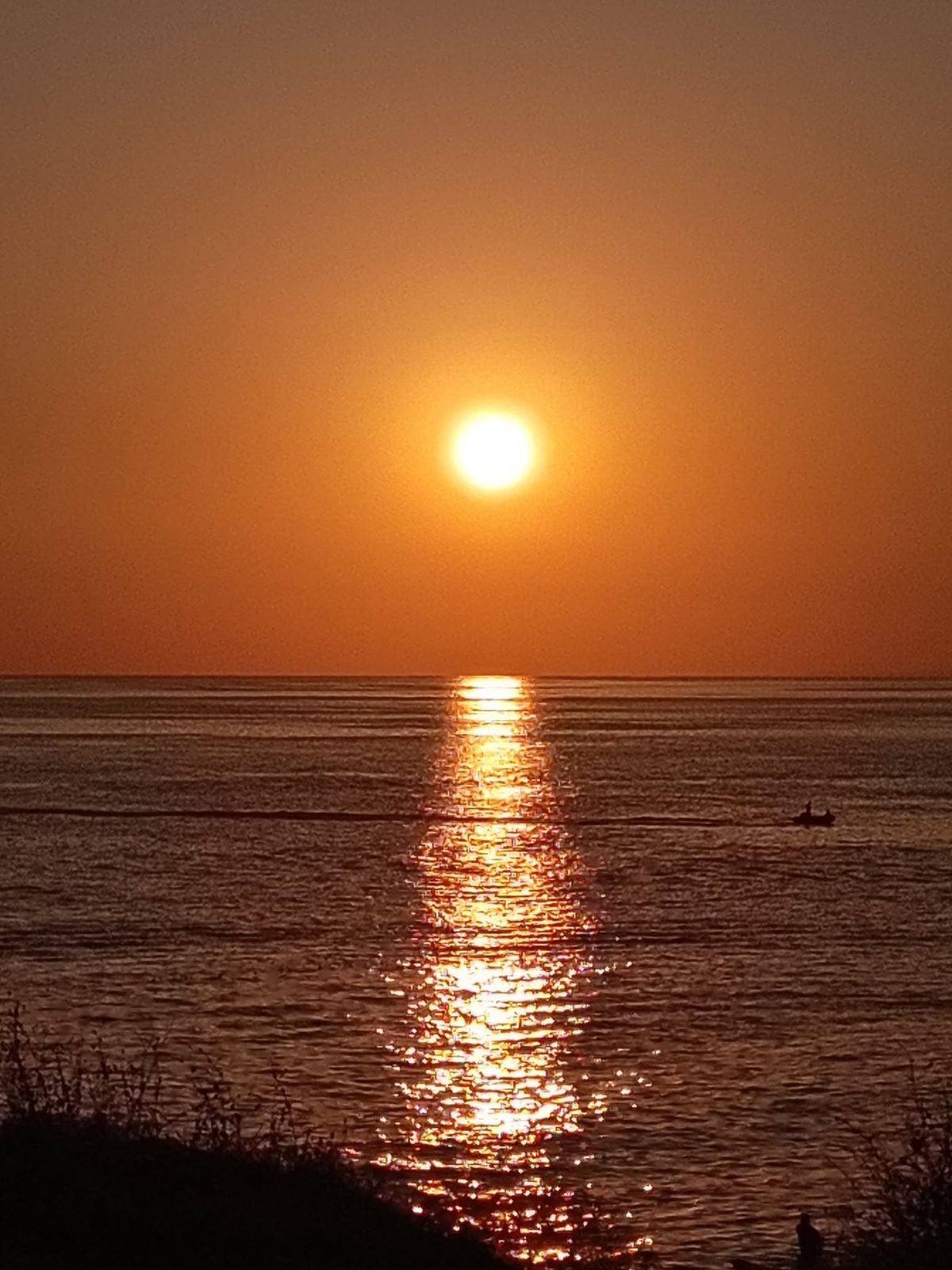 Sunset over the sea: the sun sinks toward the horizon.